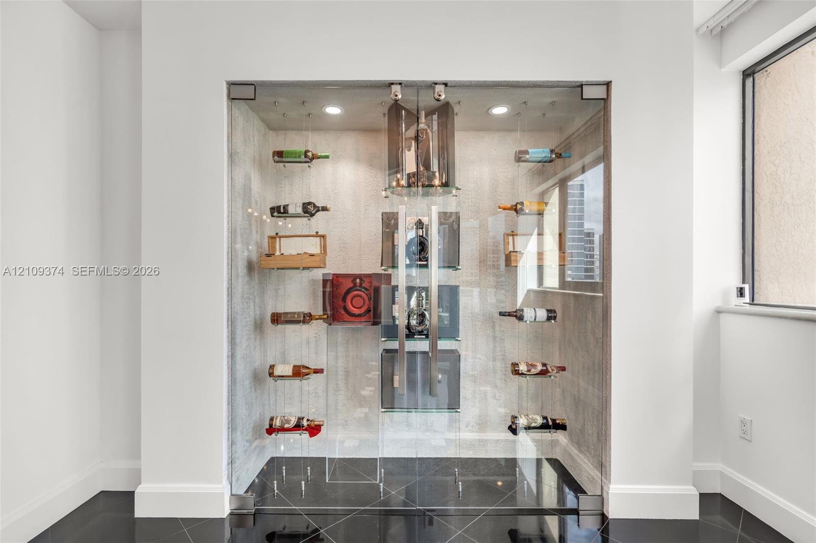 Custom climate-controlled display enclosure featuring floor-to-ceiling glass paneling, metal racking systems, integrated recessed lighting, and high-g