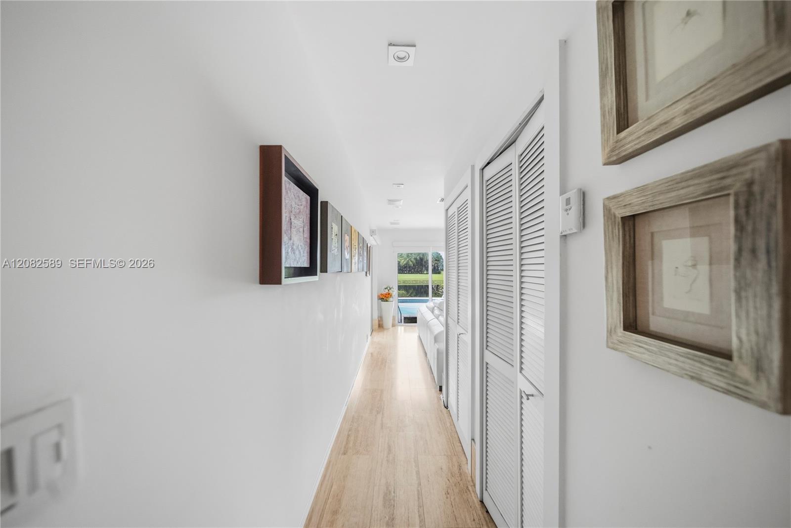 Bright hallway featuring clean lines, ample storage, and a beautiful view toward the pool.