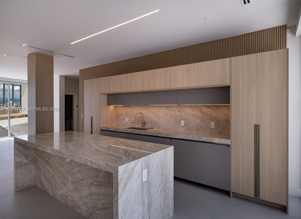 Open-concept space featuring floor-to-ceiling glass panel walls, wood-finish flooring, recessed square lighting, linear cove lighting, and a wall-moun